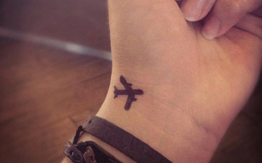 teenagers wrist with tattooed plane